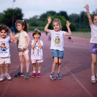 Devojčice se igraju na atletskoj stazi, sportanac majice